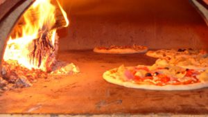 Holzofenpizza im Buchenholz Feuer in der Pizzeria in Regensburg
